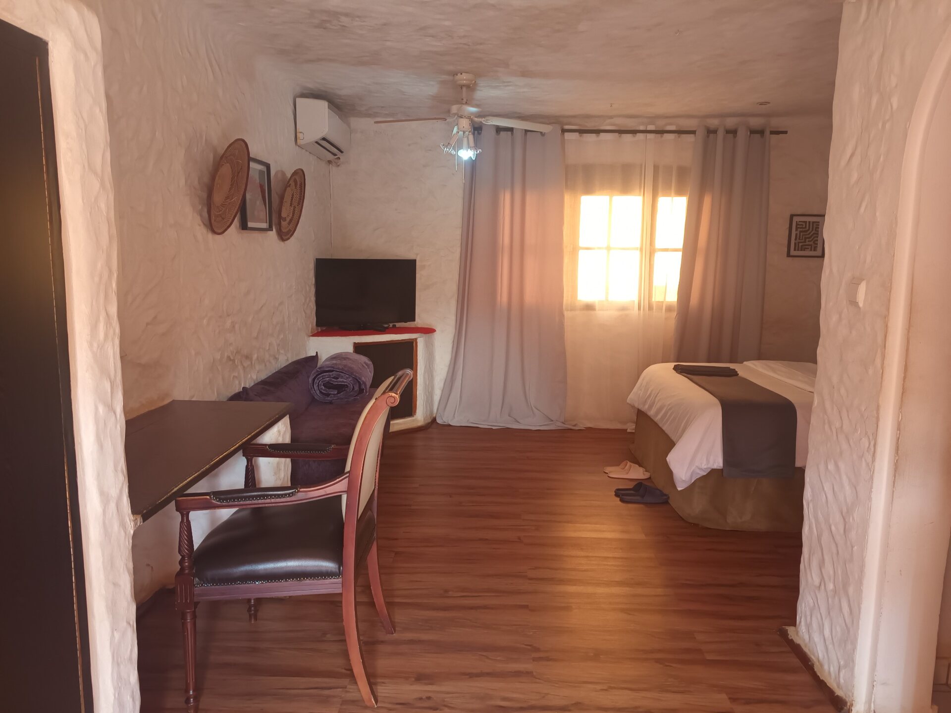Chambre spacieuse avec lit, bureau et coin salon